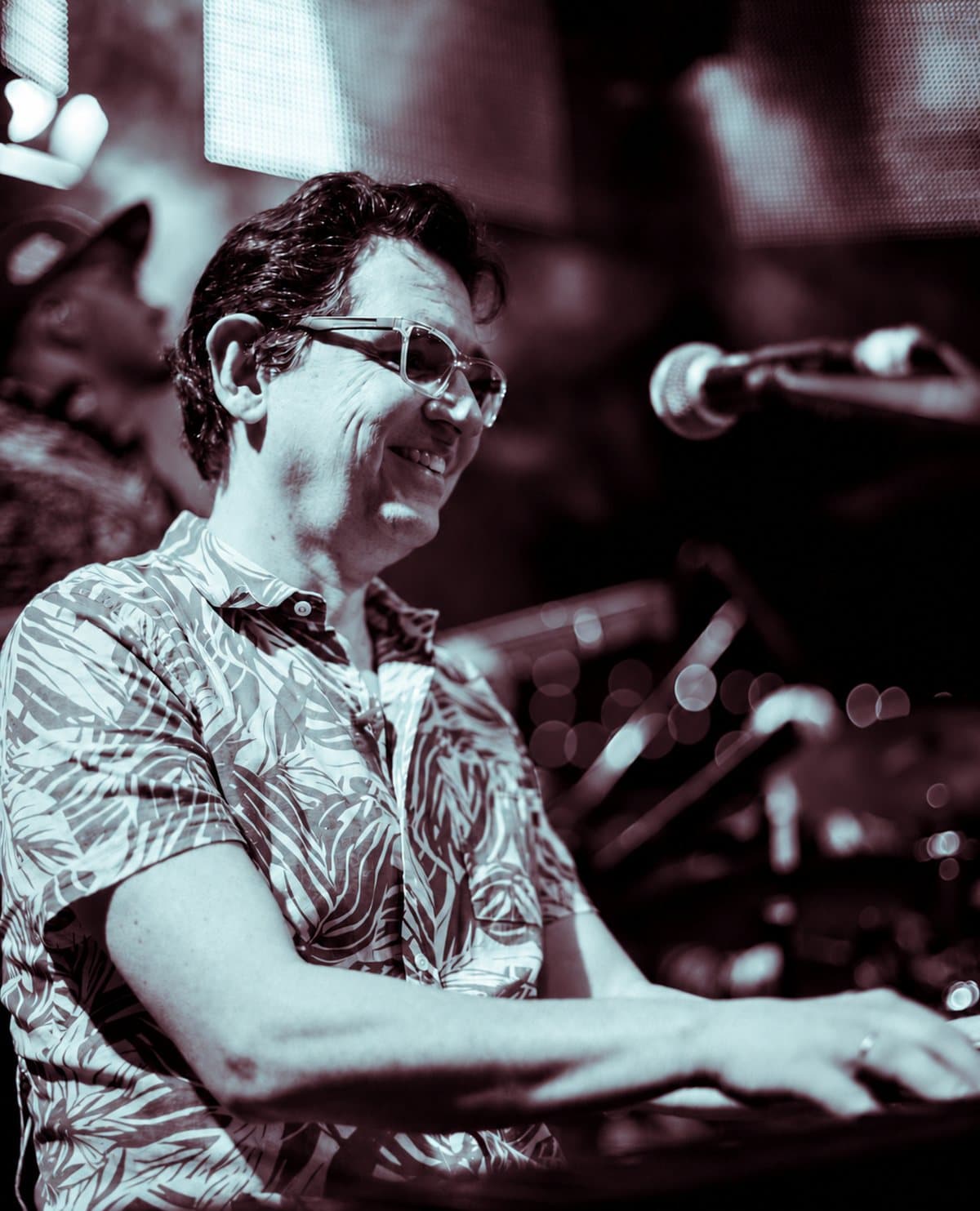 Eduardo Maya Posada al piano, sonriendo en tarima